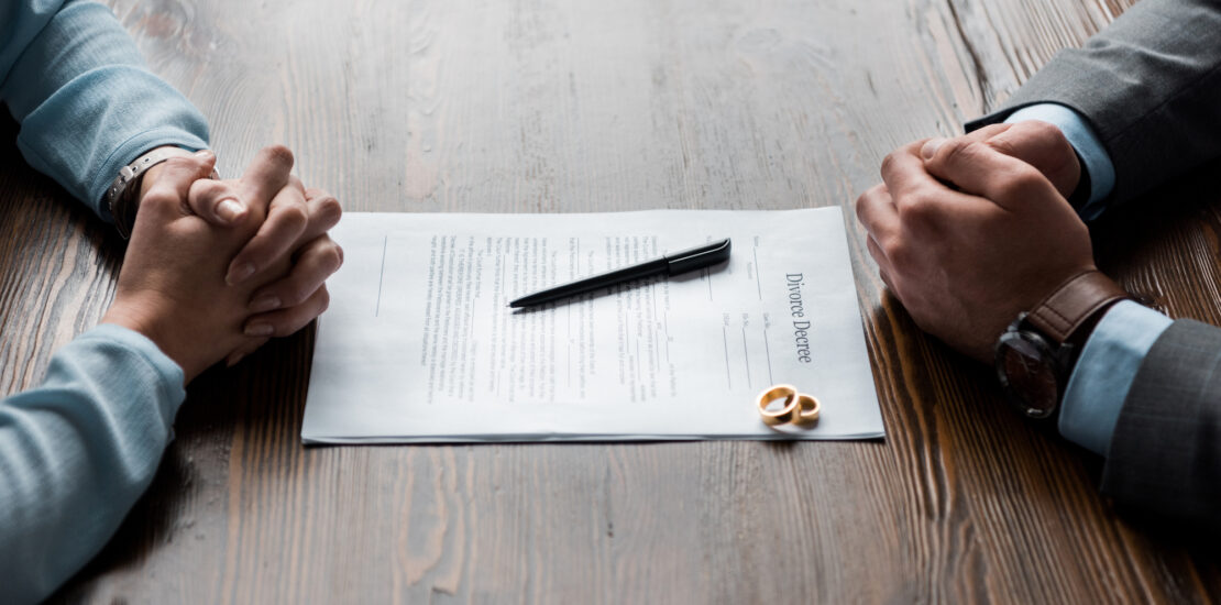 How A Divorce Lawyer Can Help You - divorce papers at table prepared to sign